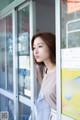 A woman leaning against a glass door in front of a store.