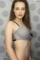 A woman wearing a gray bra and black panties.