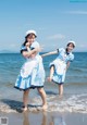 A couple of women standing on top of a beach.